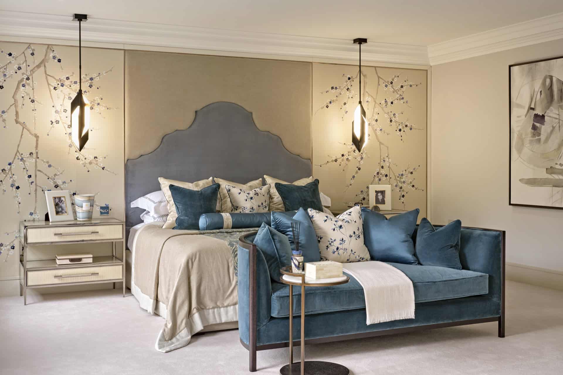 Luxury bedroom with blue velvet sofa, embroidered floral wall panels, and bespoke upholstered headboard